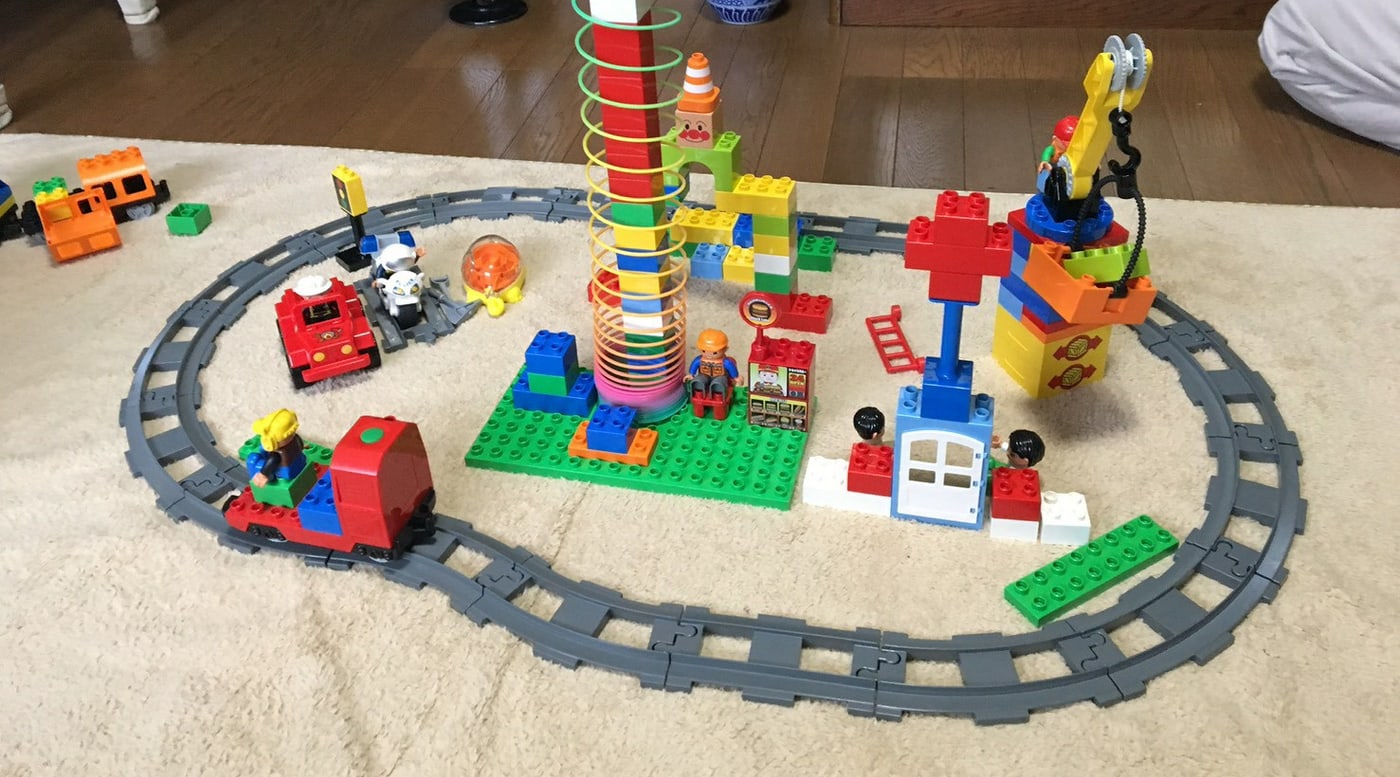 カーペットの上に広がる、ブロックと列車で作られた遊びの世界